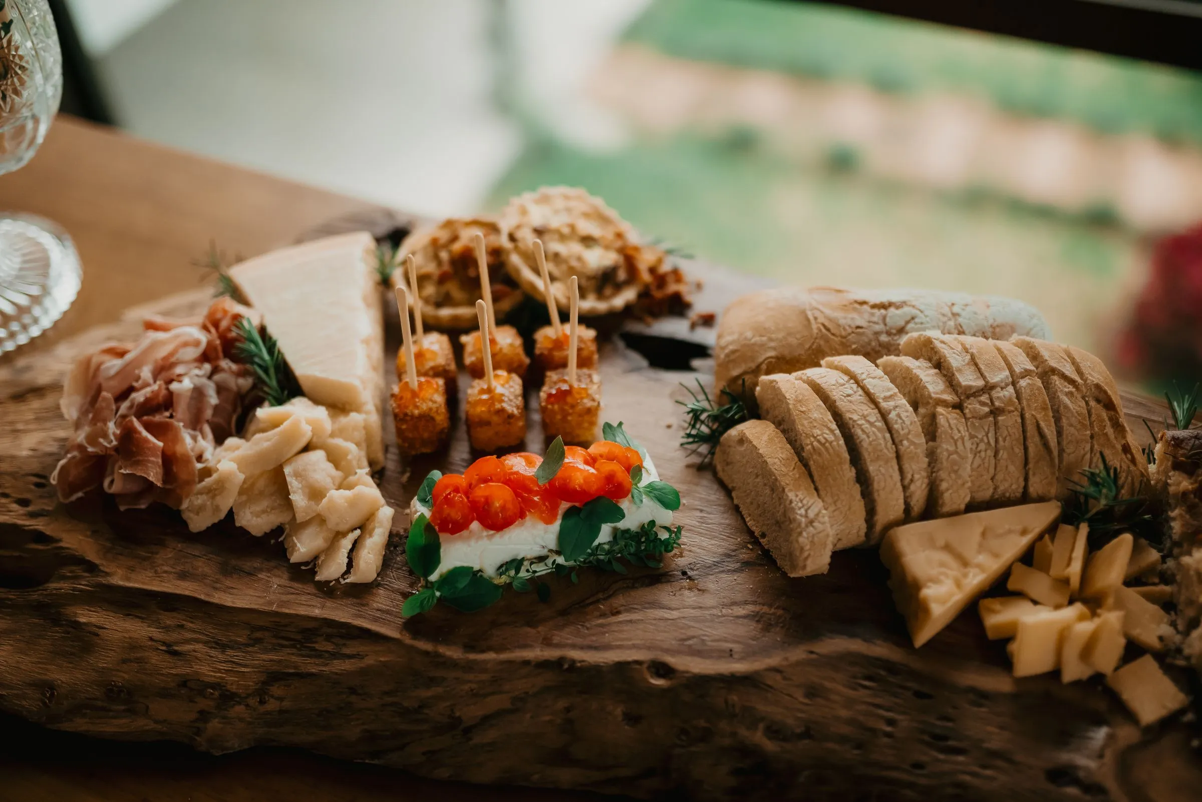 An artisan spread of cheese, cured meats and fresh bread on a rustic wooden board
